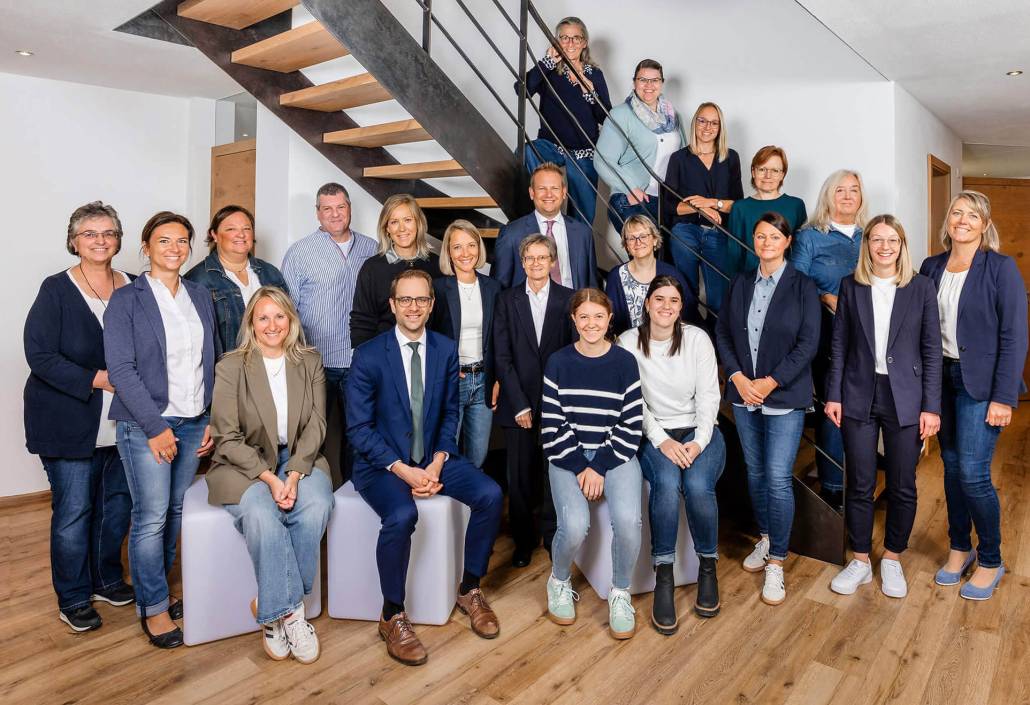 Das Team der Glensk + Partner Steuerberater PartG mbB steht in ihrem Büro bei der Stiege für ein Teamfoto.